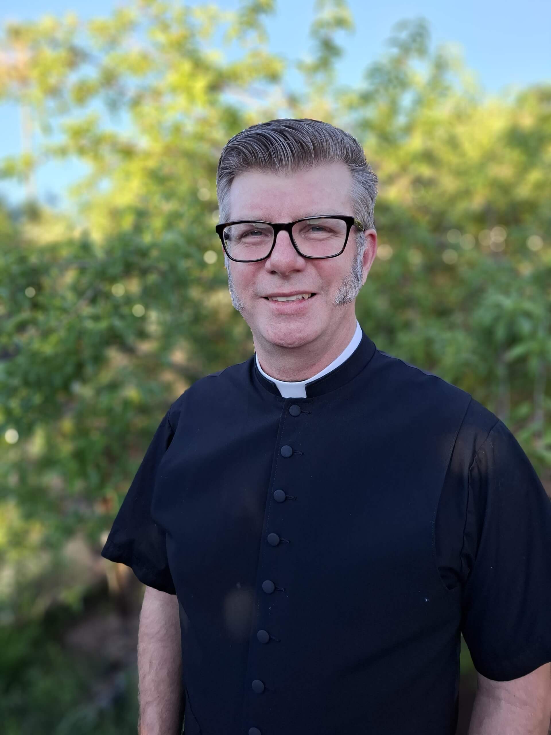 Clergy member in cassock at King of Grace Anglican Church Tucson Arizona outdoors portrait