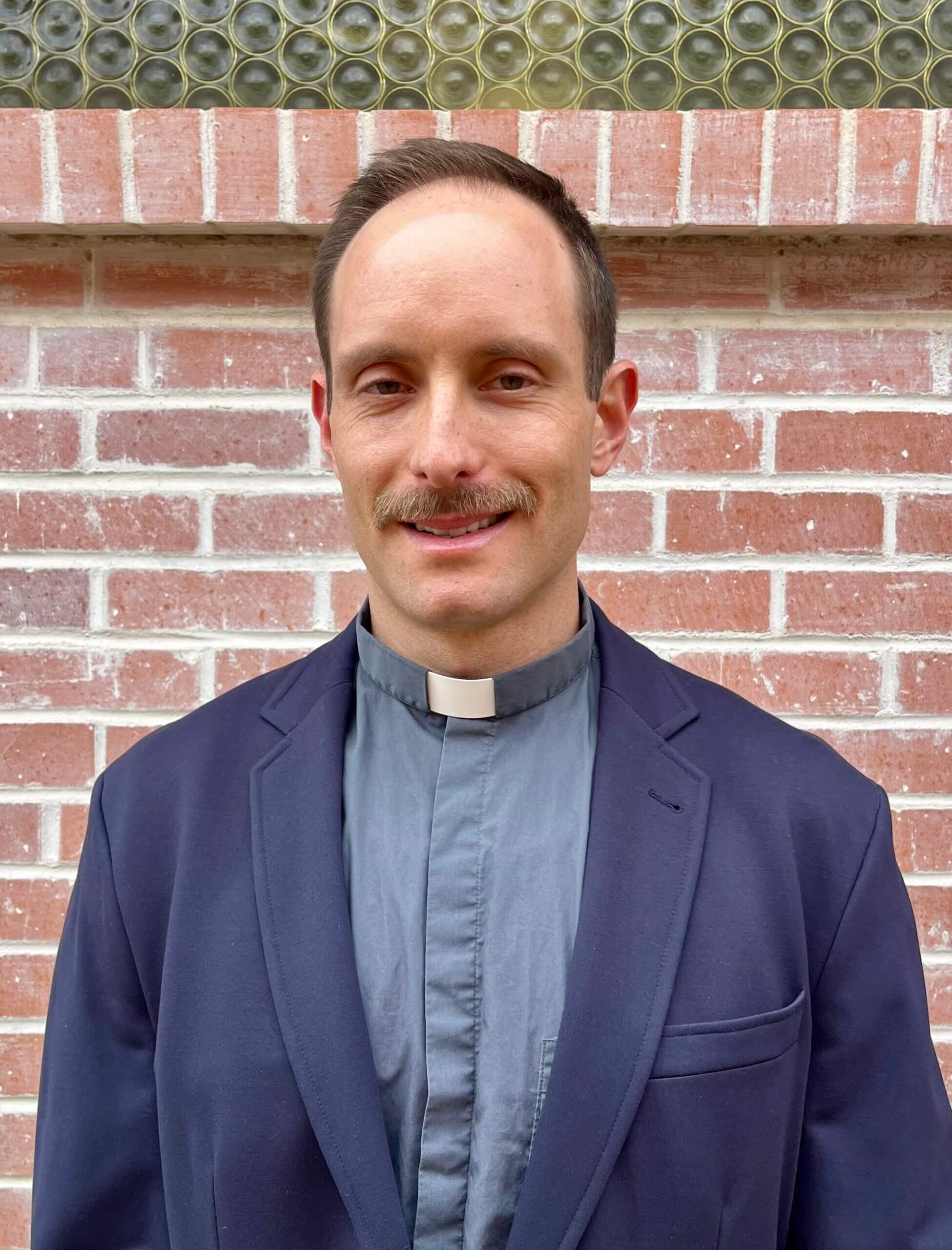 Anglican priest portrait at King of Grace Anglican Church in Tucson AZ wearing clerical collar and blazer