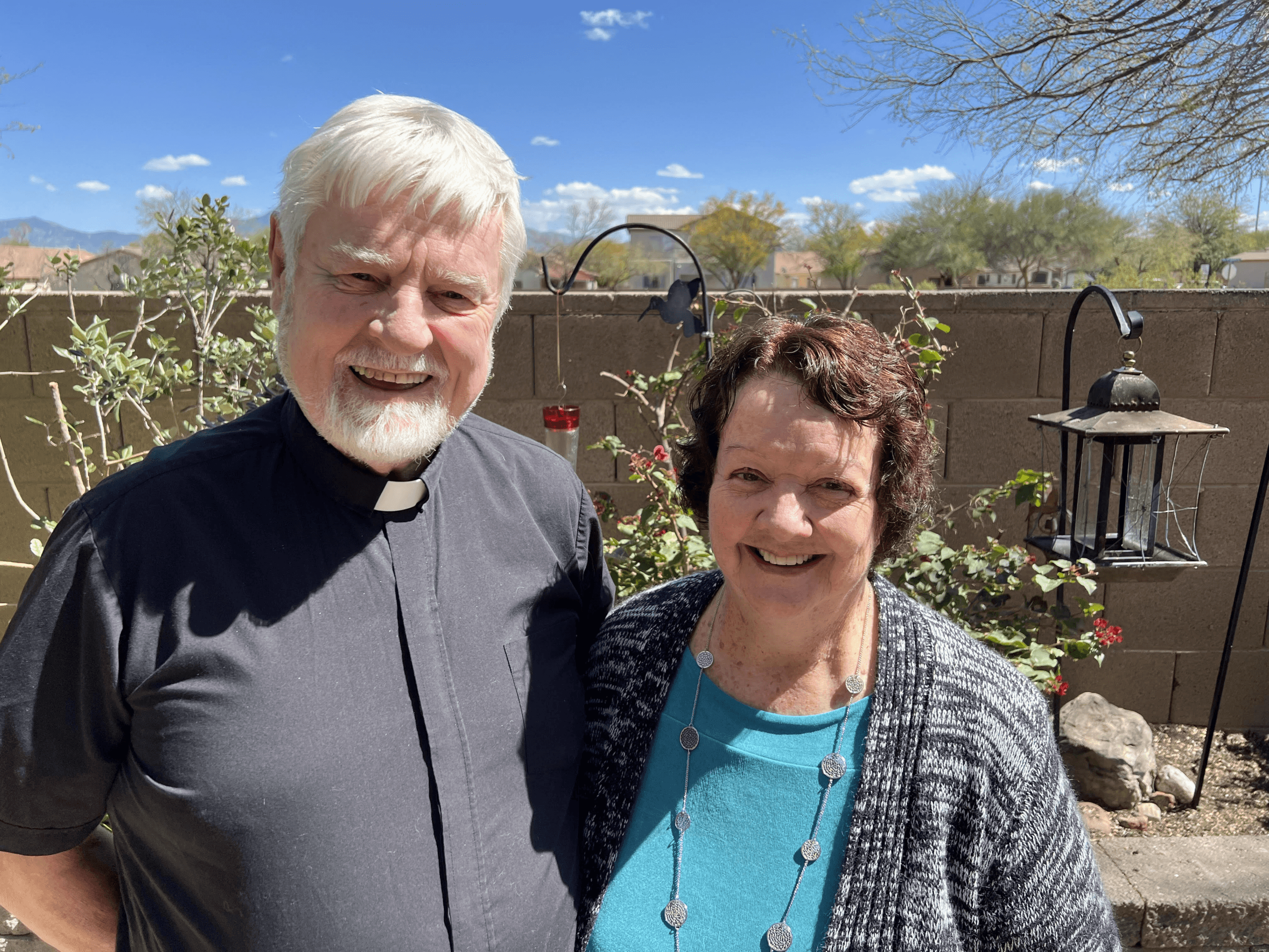 Smiling clergy couple standing outdoors from King of Grace Anglican Church in Tucson, Arizona